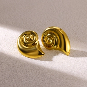 Macro shot of gold-plated stainless steel seashell earrings with spiral textures