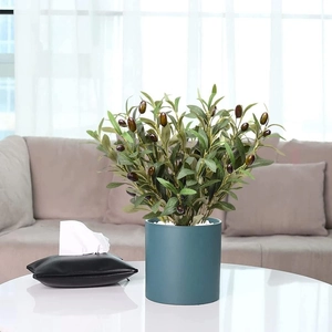 Artificial olive tree in blue pot with green leaves and purple berries for home decor