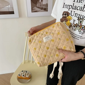 Quilted floral cosmetic bag with yellow checkers and a smiling flower pattern
