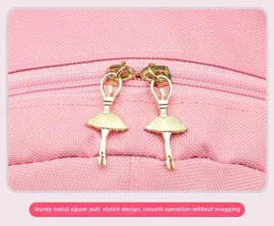 Detailed macro view of golden ballet dancer shaped metal zippers on a pink dance bag
