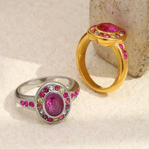 Macro detail of 18K gold and silver rings with pink gemstones and colorful zircon pavé
