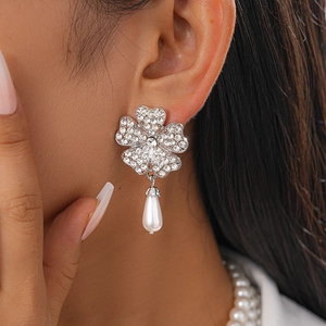 Close-up of floral crystal earrings with water drop pearls on model