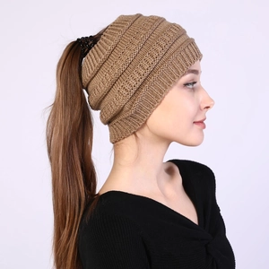 Macro detail of thick knit texture and ponytail opening on brown knitted headband hat