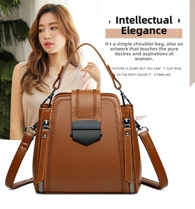 Detail of vintage brown leather handbag featuring V-shaped stitching and shield-style metal clasp