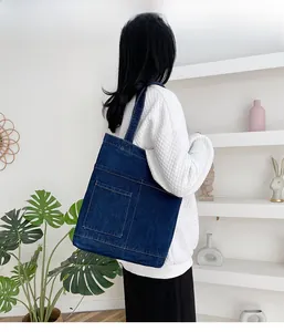 Borsa tote in denim blu scuro con tasche funzionali in un ambiente domestico