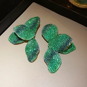 Détail de boucles d'oreilles fleurs en cristal avec dégradés verts et dorés
