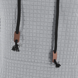 Detail aus grauem Waffelstrick mit schwarzem Kordelzug und braunem Lederbesatz-Akzent