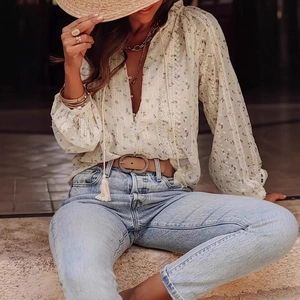Detail of floral long sleeve shirt with intricate lace stitching and tassel V-neckline
