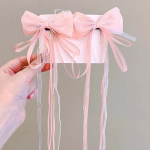 Detail of handmade pink and white ribbon bow hair clips with long streamers for girls