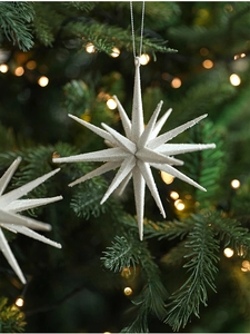 Sparkling white star ornament with glitter finish hanging on a festive Christmas tree