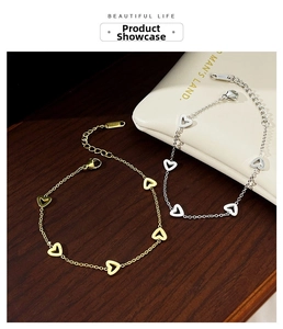 Detail of adjustable heart charm bracelets in gold and silver with lobster clasp