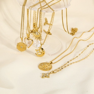 18K gold plated stainless steel necklaces with heart, sun and eye charms on satin background
