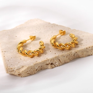 18K gold plated stainless steel C-shaped twisted hoop earrings on beige stone base
