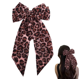 Detail of leopard print bow hair clip with long ribbons on white background and model view