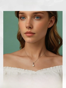 Close-up of a white rose pendant on a silver necklace worn by a fashion model