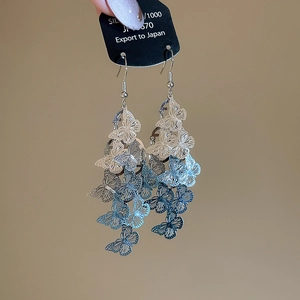 Détail du crochet d'oreille papillon bleu avec design d'aile évidé élégant pour femme