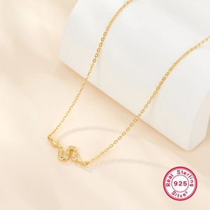 Detailed macro view of S-shaped snake pendant in 925 sterling silver with sparkling crystals