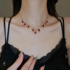 Close-up of red teardrop gemstone necklace with sparkling crystals on model