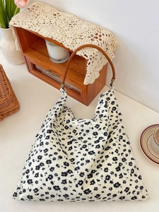 Sac cabas en toile à fleurs avec anses en cuir marron dans un décor minimaliste