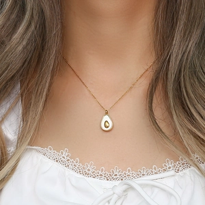 Minimalist gold stainless steel avocado pendant necklace worn on a woman's neck