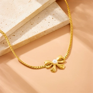 Elegant gold bow necklace with a white pearl pendant on a sleek flat snake chain