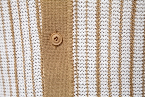 Macro shot of vertical brown and white stripes on a knitted polo shirt with button detail