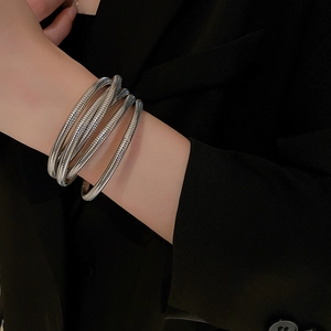 Close-up of a silver multi-layered elastic spiral cuff bracelet worn on a wrist