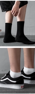 Detail of black ribbed mid-calf crew socks and white ankle socks in premium cotton blend