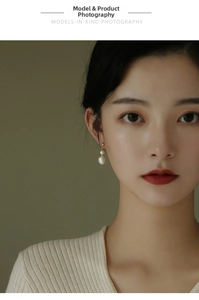Close-up of elegant freshwater baroque pearl drop earrings on model in vintage style