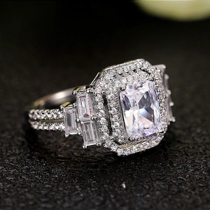 Macro di un anello in argento con un grande zircone rettangolare e incastro halo