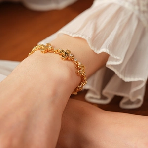 Vue détaillée d'un bracelet vintage en or avec fleurs de lys et zircons brillants