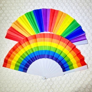 Rainbow folding fans with white plastic ribs on lace background for dance and props