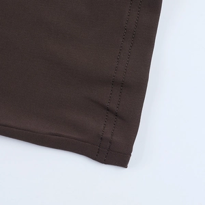 Détail macro du tissu tricoté marron foncé avec couture précise à double aiguille sur l'ourlet
