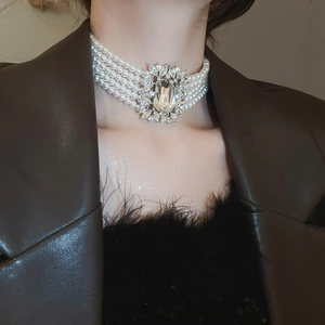 Detail of multi-layer pearl necklace with a large rectangular crystal pendant centerpiece