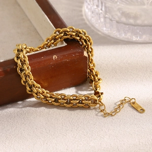 Macro shot of 18K gold lantern chain bracelet on wood with K18 engraved tag