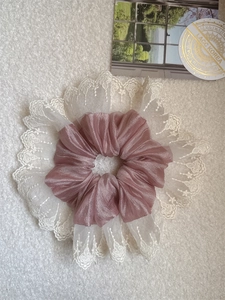 Detail of elegant double-layered lace scrunchie with pink satin and white floral embroidery
