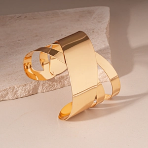 Vue détaillée du bracelet jonc doré multicouche croisé avec finition en métal poli