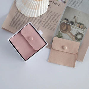 Detail of pink and beige velvet jewelry pouches with snap buttons in a stylish gift setting
