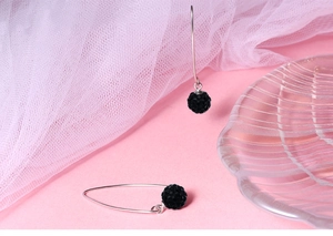 Close-up of black disco ball earrings with silver hooks and sparkling rhinestone details