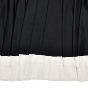 Detailed view of black pleated fabric and double-layered white mesh lace hemline