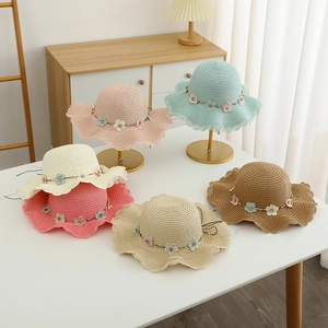 Détails de chapeaux de paille avec bords ondulés et fleurs en perles de différentes couleurs
