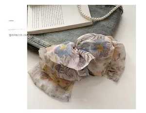 Détail d'un nœud papillon en mousseline florale avec tissu multicouche sur fond denim
