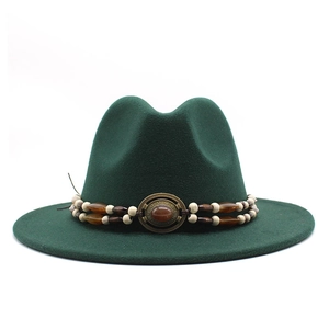 Detail of dark green wool fedora hat featuring beaded band and vintage metal buckle
