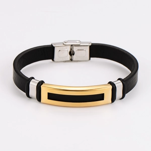 Close-up of black leather men's bracelet with gold and silver stainless steel accents