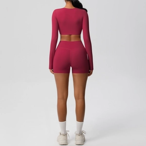 Rear view of berry pink seamless yoga set showing high waist shorts and cropped long sleeve