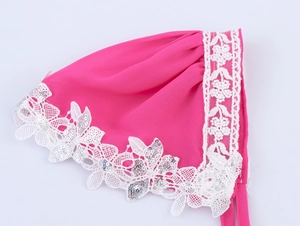 Dettaglio sottovelo in chiffon rosa con pizzo floreale bianco e paillettes d'argento
