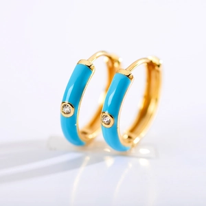 Macro view of blue enamel gold-plated hoop earrings with sparkling zircon inlay detail