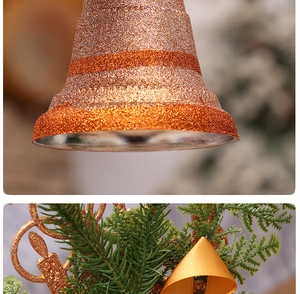 Detailed close-up of golden glitter bells with green pine needles for Christmas decoration