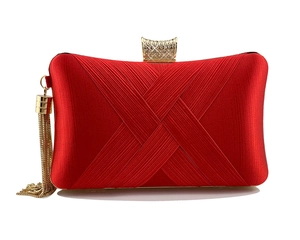 Macro view of red satin evening clutch with woven texture, rhinestone clasp, and gold tassels