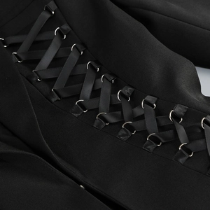 Detail of cross-lace corset waist with black satin ribbons and silver eyelets on a blazer dress